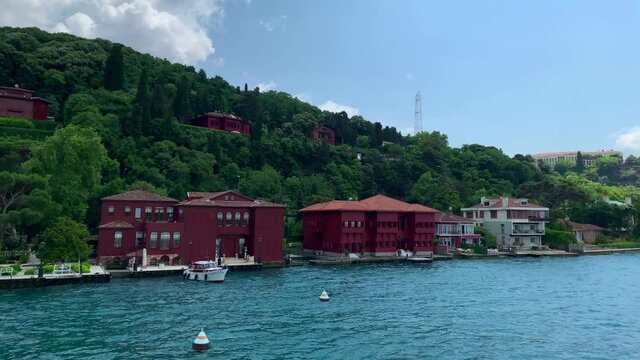 Footage of historical mansions and houses by Bosphorus in upscale neighborhood "Anadolu Hisari" in Istanbul. It is a beautiful summer scene on cloudy summer day. Camera moves forward.