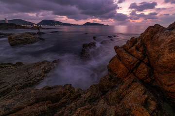 Fototapeta premium Long exposure image of Dramatic sky seascape with rocks in the foreground sunset or sunrise over sea scenery background.