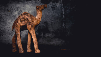 Silhouette of a camel on a wall and woode background. Background of annual rings. Camel for travelers.	