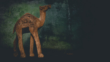 Silhouette of a camel on a wall and woode background. Background of annual rings. Camel for travelers.	