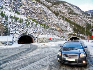 Car in front of a tunnel, winter landscape of Norway.