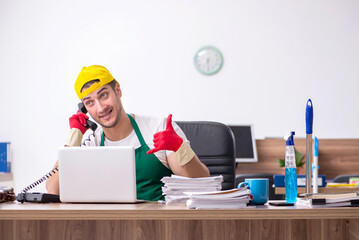 Young male contractor cleaning the office