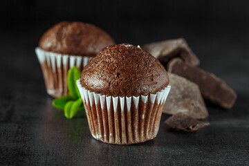 Chocolate cupcake with icing and chocolate bar in Dark lighting,Homemade delicious chocolate muffin...