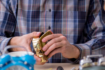 Young male watchmaker working in the workshop
