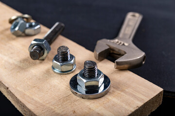 Metal bolts and nuts for joining wood. Tightening the screws with an adjustable wrench.