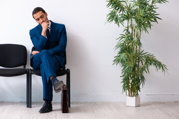 Young businessman waiting for an interview at hall