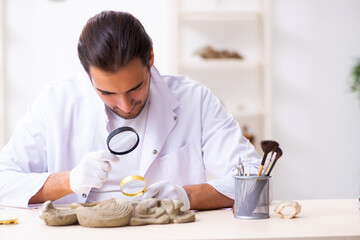 Young male archaeologist studying ancient african stonemask