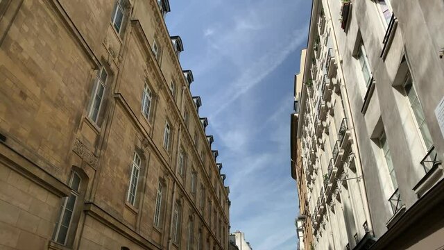 Bottom footage of historical, traditional buildings in Saint-Michel area of Paris showing architectural style of French architecture. It is a sunny summer day. Camera moves forward.