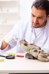 Young male archaeologist studying ancient african stonemask