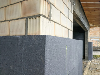 Black polystyrene foamboard on the house wall