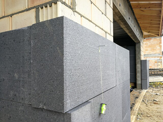 Black polystyrene foamboard on the house wall