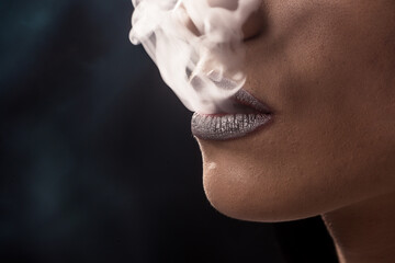 Silhouette of smoker exhales smoke
