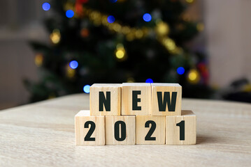 new year concept. font 2021 on wooden cubes on tree background