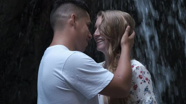 Young couple Enjoying Waterfall and kissing