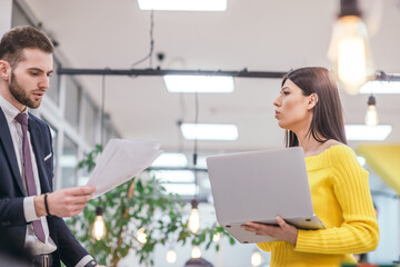 Angry executive director (businessman) throwing paperwork, documents handed over by his employee while standing in the office in front of the coworkers, team.