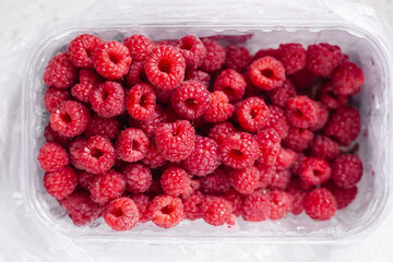 Fresh juicy Raspberries on the table. close up raspberry in the container. autumn harvest. healthy food. Pink ripe berries, sweet natural diet snack