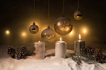 Creative artwork decoration. Christmas decoration with burning candles on a dark background. Christmas ornaments over dark golden background with lights.