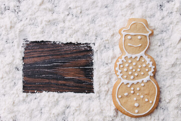 Christmas and New Year traditional attribute, festive sweets for kids, celebration mood. Homemade gingerbread snowman cookie on wooden table
