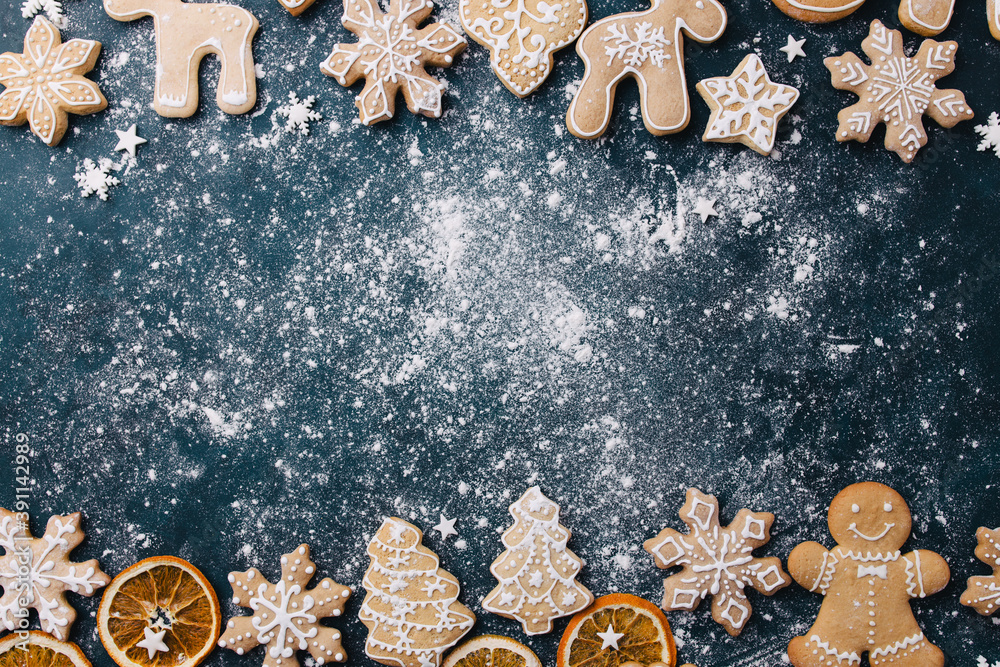 Wall mural Christmas composition, New Year greeting card. Mockup with festive food decorations and gingerbread cookies on blue background. Copy space.