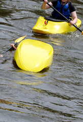 A kayak overturns in a boating accident and  another boater comes to the rescue