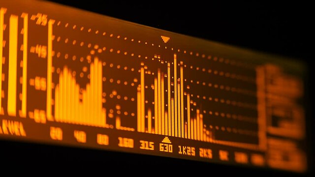 The professional concert equalizer has a yellow spectrum analyzer on the display that analyzes the frequency range of music or any sound and can change it. Closeup