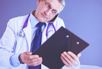 Male doctor writes notes on the clipboard in the hospital