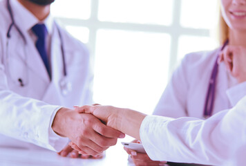 Doctor shaking hands with a male patient in the office