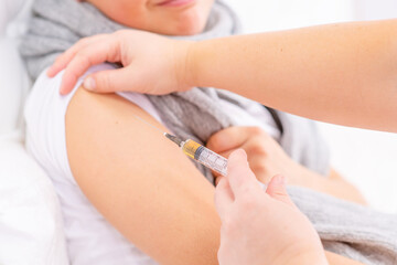 A sick boy is given a shot in the forearm during treatment
