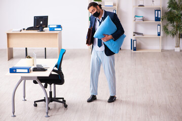 Young male employee during pandemic at workplace