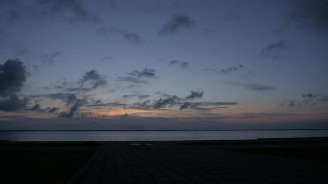 Early morning sunrise over lagoon, static time lapse.