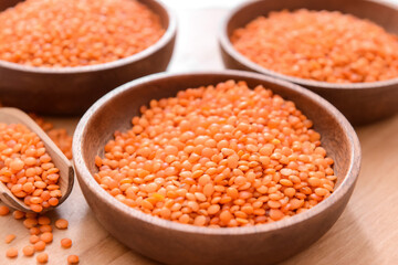 Bowls with raw lentils on table, closeup