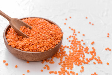 Bowl and scoop with raw lentils on table