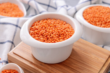 Bowls with raw lentils on table