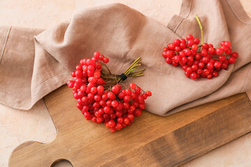 Board with fresh viburnum berries on table