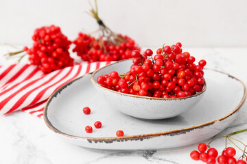 Bowl with fresh viburnum berries on table