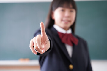 教室で指差しをする日本人女子中学生