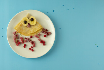 Baby breakfast with fruits and berries. Pancake in the form of an octopus 