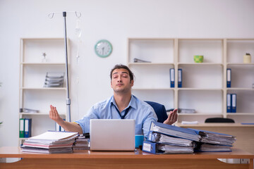 Young male employee suffering at workplace