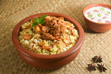 Mutton biryani , Gosht or lamb biryani or Hyderabadi Dum biriyani with raita yoghurt dip special occasion festival food  for Ramadan , Eid Hyderabad India.