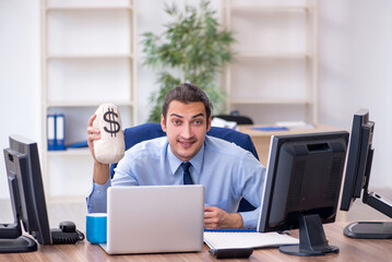 Young male employee holding moneybag in the office