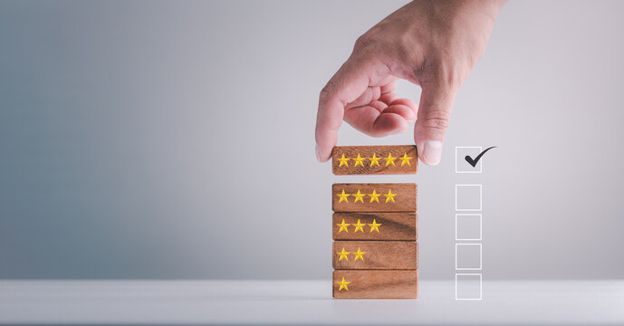 feedback rating and positive customer review experience, service and Satisfaction, Business people are Choosing wood block with 5 star icon to give satisfaction in service. rating very impressed.
