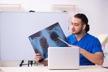 Young male doctor teacher radiologist in front of whiteboard