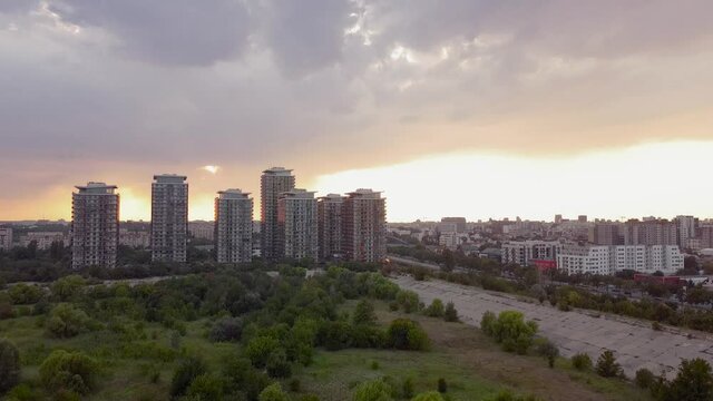 City panorama tilting up-down drone movement at sunset. The shot was taken at Vacaresti Urban Delta looking over the central area of Bucharest, the capital city of Romania.