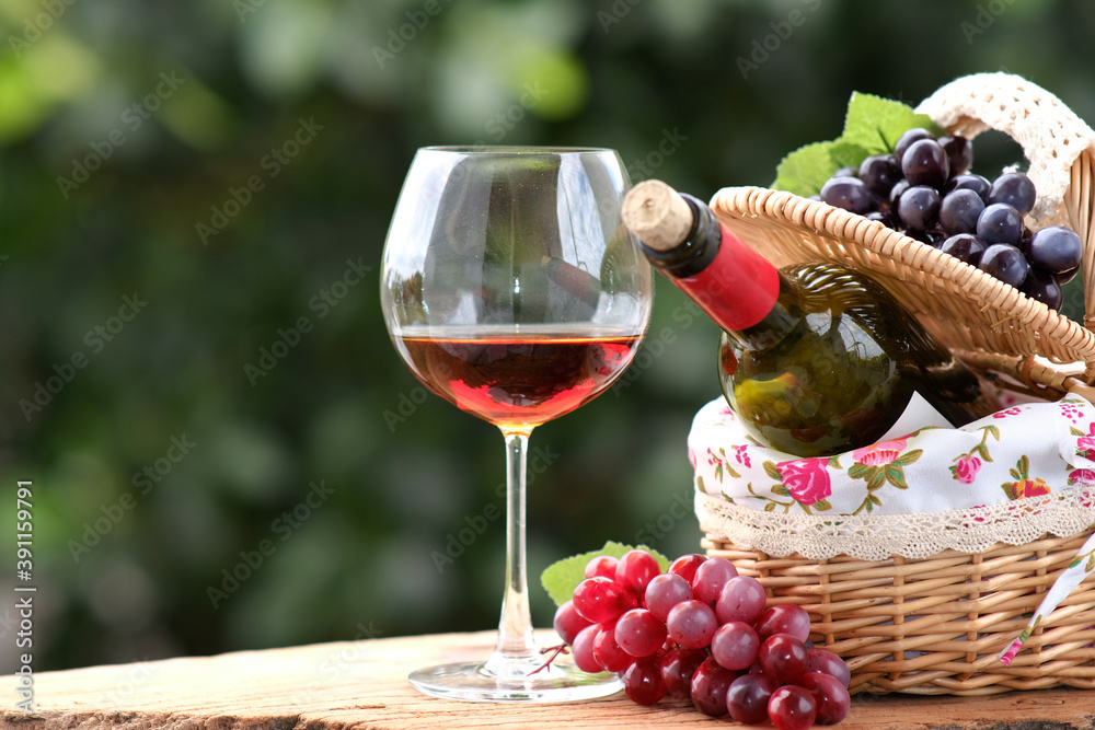 Sticker Red wine in basket on wood table background and space for text