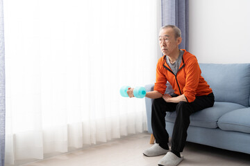 ダンベルで筋トレをするシニア男性