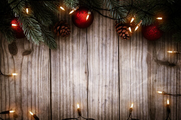 Christmas background - Christmas lights bulb and pine leaves decoration on  wood table, frame border design. Merry Christmas and New Year holiday background. top view.