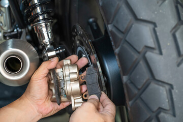 mechanic Replace and adjust motorcycle Rear Brake system,maintenance,repair motorcycle concept in...