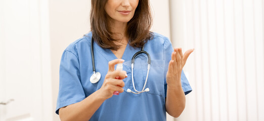 Banner of closeup with young female doctor using sanitizer gel.