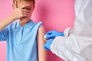 male doctor giving vaccine shot to frightened child boy, kid is afraid of injections. prevention, protection and immunization concept