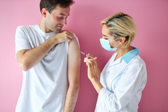 female doctor wearing mask and man patient getting injection vaccine, medicine flu man doctor insulin health drug influenza concept